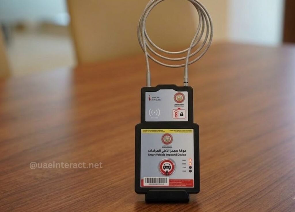 - UAE Interact Smart Vehicle Impound Device with coiled cables on a wooden table; Arabic labels and official seals and icons on the front panel